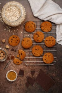 Cookies vegan dorés sur les bords et moelleux au centre, disposés sur une grille de refroidissement.